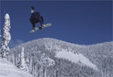 A snowboarder airborne above a snowy slope