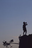 A person silhouetted on a rocky ridge