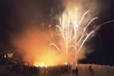 Fireworks rising above a snowy slope at night