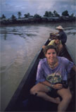 Passengers seated in a narrow river boat