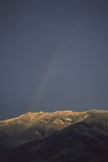A rainbow above sunlit mountain ridges