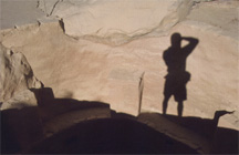 A photographer’s silhouette cast onto a rock wall