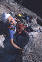 A helmeted climber beside a rock face