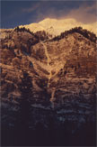 Sunlit rock ridges above a dark mountainside