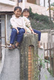 A person seated beside a path