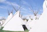 White tipis beneath a blue sky