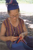 A seated woman working with fabric